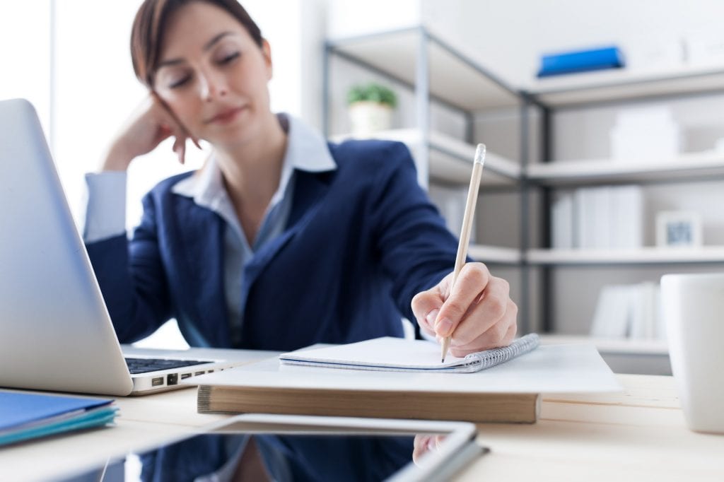 Businesswoman writing notes on a notebook